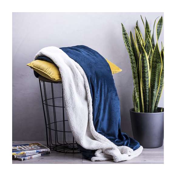 Manta en elegante diseño bicolor de 125x160cm. En suave y cálida combinación de materiales coral fleece y sherpa de 380g/m2. Presentada en cinta con lámina para fácil impresión.