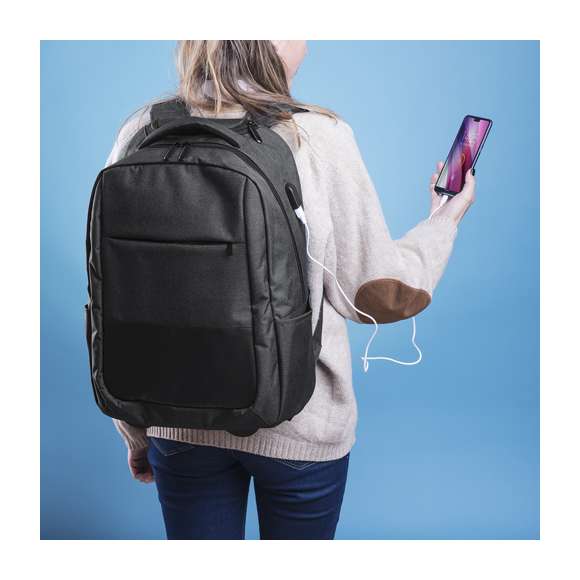 Mochila trolley en resistente poliéster 300D. Con conexión USB -powerbank no incuido- y bolsillo interior acolchado para ordenador portátil de hasta 15 pulgadas y compartimento para tablet de hasta 10 pulgadas. Bolsillo principal con doble tirador, bolsillos lateral y frontal. Compartimento para mecanismo de trolley con cierre de cremallera, asa reforzada y accesorio cubre ruedas con fijación de velcro. Espalda acolchada y cintas de hombros ajustables con acolchado.
