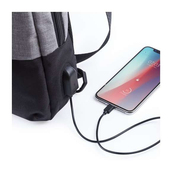  	Bandolera multiusos en resistente poliéster 300D. De atractivo diseño urbano, en combinación de colores gris denim y negro. Con conexión USB para carga -powerbank y cable no incluídos- y bolsillo acolchado para tablet de hasta 10 pulgadas. Espalda y cinta acolchadas, con cinta de ajuste regulable. Bolsillo principal de fácil apertura, con cierre de cremallera y resistentes tiradores.
