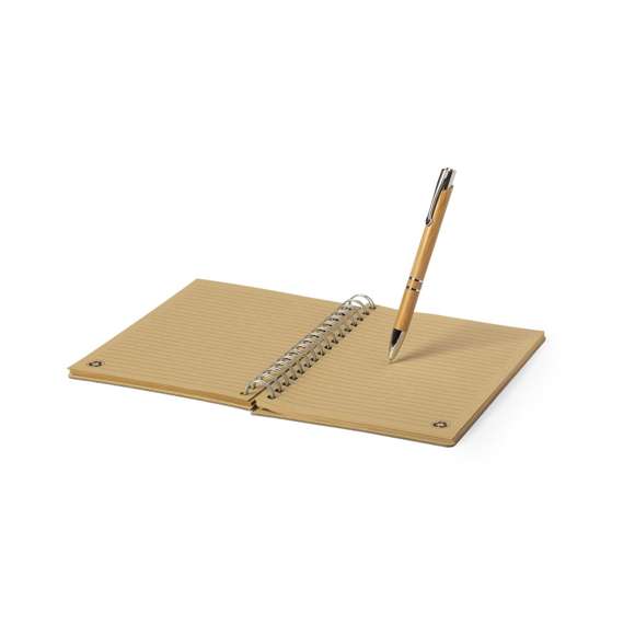 Set de libreta y bolígrafo en línea nature. Incluye libreta de anillas con tapas rígidas en bambú, con 80 hojas de disposición a una raya y diseño eco. Bolígrafo de mecanismo pulsador, con cuerpo en bambú y accesorios metálicos -cartucho jumbo y tinta negra-. Presentado en estuche de cartón troquelado y diseño eco.