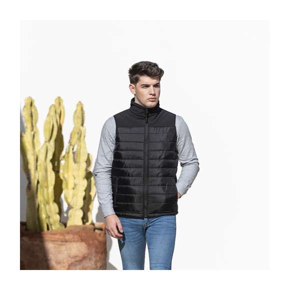 Chaleco impermeable y transpirable en combinación de materiales soft shell y poliéster. De elegante construcción en color negro, con cierre de cremallera y bolsillos laterales de cremallera con tiradores para fácil apertura. Disponible en tallas S, M, L, XL, XXL.
