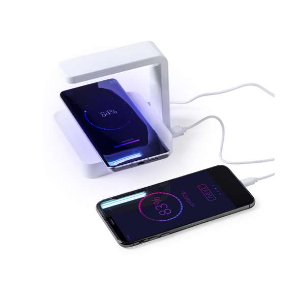 Lámpara esterilizadora de luz ultravioleta tipo C con cargador inalámbrico integrado para smartphone. Especialmente diseñada para la eliminación de microorganismos y bacterias en objetos de uso cotidiano como el smartphone, llaves, gafas, mascarilla, auriculares, smartwatch… Fabricada en resistente material ABS de acabado brillante y presentada en atractiva caja individual de diseño.  Fácil de usar, basta con situar el objeto a esterilizar en la base de la lámpara. Potencia de salida 2,5W y longitud de onda de 254 nm. Salida USB de 1000 mA, con función de carga rápida 10W y cable micro USB incluido a juego de 1 metro de largo. Tiempo de esterilización de 15 y 25 minutos con función autoapagado.  Disponible manual de usuario en español e inglés. Disponible certificación CE, RoHS y de efectividad germicida. Para un uso adecuado del producto, evitar el contacto con la piel y los ojos.