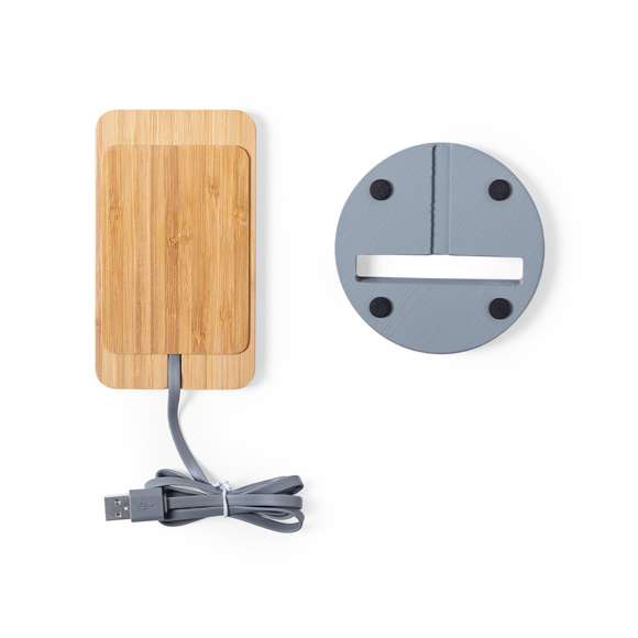 Cargador inalámbrico con función soporte para smartphone. Fabricado en combinación de piezas de bambú de corte nature y cemento de piedra caliza, un conglomerante formado por la mezcla de materiales naturales, principalmente piedra caliza molida y agua, obteniendo un material de gran consistencia y durabilidad.  Indicador led, cable de carga USB a juego y compatible con dispositivos equipados con tecnología de carga inalámbrica. Protección de seguridad para evitar sobrecalentamiento, sobrecarga y cortocircuito. Presentado en atractiva caja de diseño.