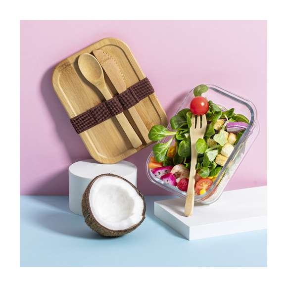 Fiambrera de línea nature de 700 ml de capacidad. Fabricada en cristal, con tapa hermética de bambú pulido, con banda de goma para evitar derrames y rebaje para usarla como bandeja. Incluye cinta de seguridad con tenedor, cuchara y cuchillo. Presentada en atractiva caja individual de diseño eco.