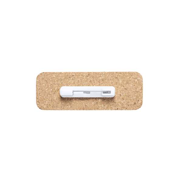 Identificador de línea nature fabricado en corcho natural, para así fomentar la utilización de materias primas naturales y reducir las emisiones contaminantes. Fijación de seguridad con imperdible en la parte trasera.