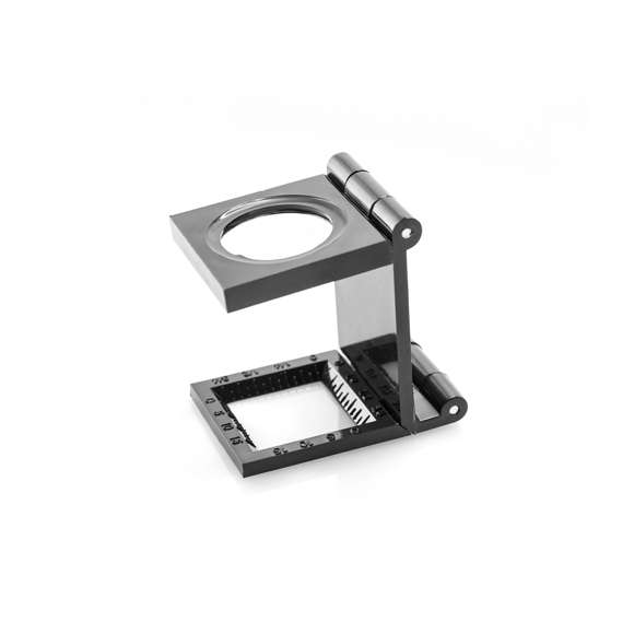 Lupa plegable cuentahilos de 7 aumentos. Con regla de medición integrada en cuerpo y presentada en caja individual.